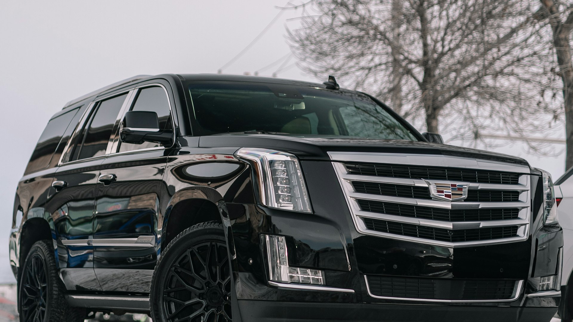 Black luxury SUV waiting curbside at dusk in Phoenix